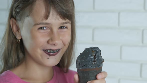 The child is stained with black ice cream. 