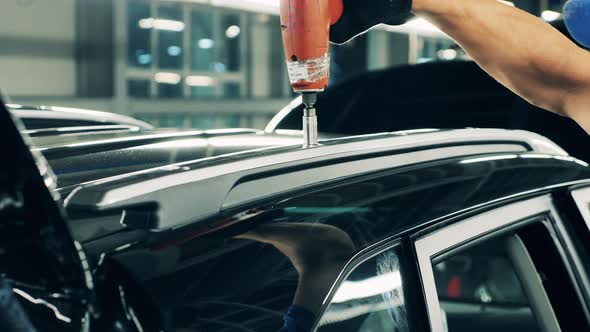 Car Manufacturing Worker Assembling a Car Roof. Close Up