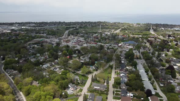 Aerial backwards flight showing rural suburb area of Hamilton District with Lake Ontario in backdrop