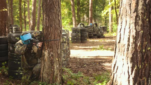 Yung Man Wearing Camouflage Protective Mask Plays Paintball Battles with Friends Leisure Activity