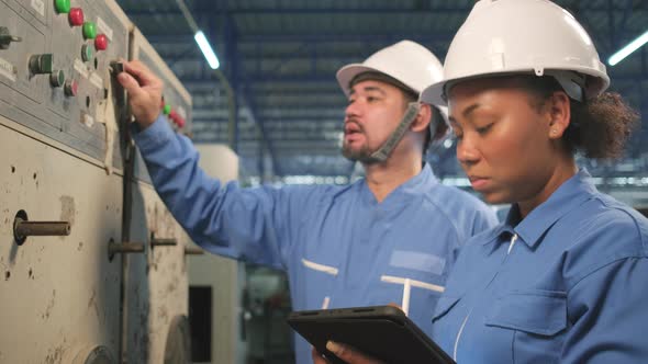 Industry engineer teams inspect machine control panels in manufacturing factory.