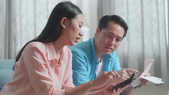 Close Up Of Asian Couple With A Laptop Helping Each Other Calculating Money By Calculator