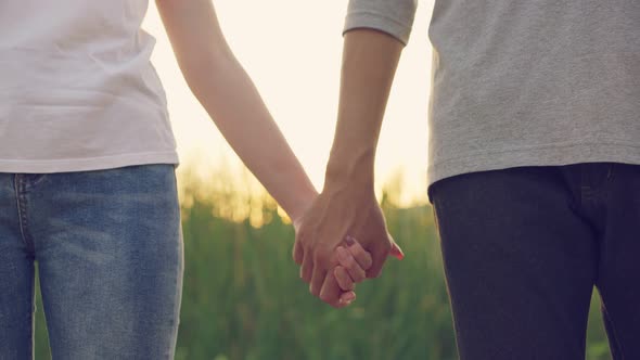 Close up shot of couple Asian man and woman standing and holding hand of each other in evening.