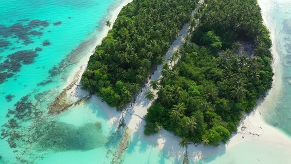 Daytime above clean view of a white paradise beach and blue sea background in vibrant 4K