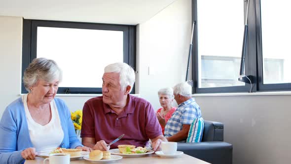 Senior couple interacting with eachother while having breakfast