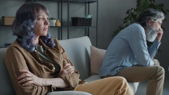 Husband and Wife Sitting on Couch During Family Fight Expressing Anger and Blame at Home