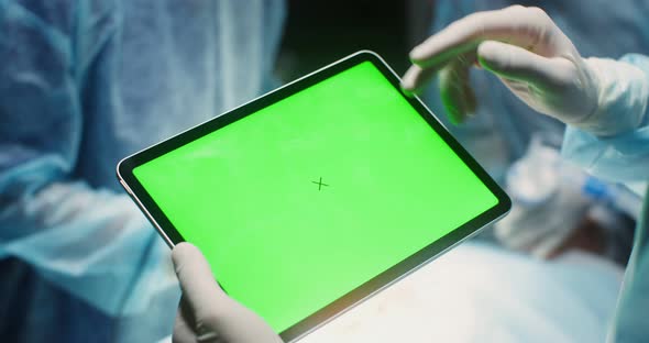 Closeup of a Digital Tablet with a Green Screen in the Hands of a Doctor