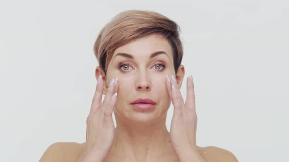 Close-up of middle aged mature woman over white background.