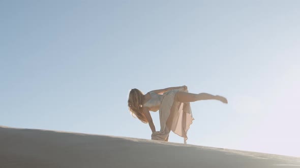 Beautiful Woman In Gold Dress Dancing On Sand