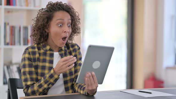 Winning, Young Mixed Race Woman Celebrating Success on Tablet 
