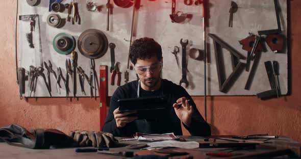 A Blacksmith Uses a Tablet to Create a Sketch of a Future Product