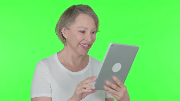 Video Call on Tablet By Old Woman on Green Background