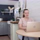 Woman is Working on Laptop Sitting at the Kitchen Table at Home - VideoHive Item for Sale