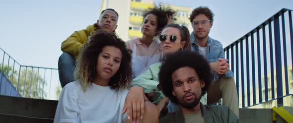 Video portrait of young group of friends sitting on the stairs. Shot with RED helium camera in 8K.