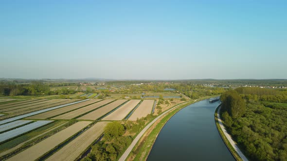 Aerial view in the sunset of a river near Clairmarais, France. There is a houseboat in the distance,