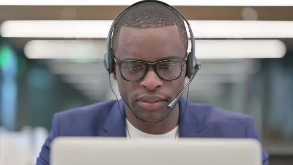 Portrait of African Businessman with Headset Working on Laptop