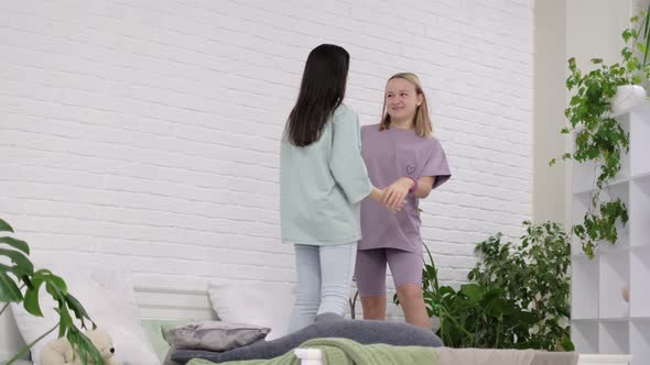 Young Girls Dancing on the Bed at Home