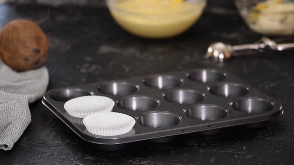 Female Hands Put a White Paper Cupcake To the Form.