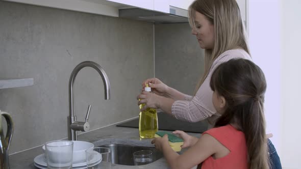 Cute Girl Helping Her Mom To Wash Dish