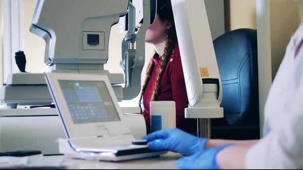 Doctor is Managing a Medical Mechanism to Check Woman's Eyes