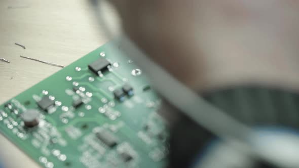 A Worker Is Working on the Creation of an Electronic Board. Close-up.