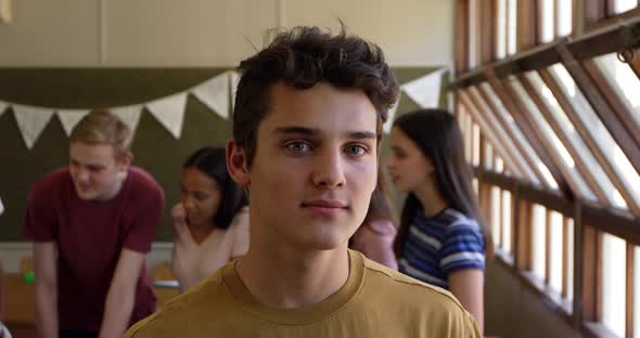 Portrait of teenage boy in school classroom alt