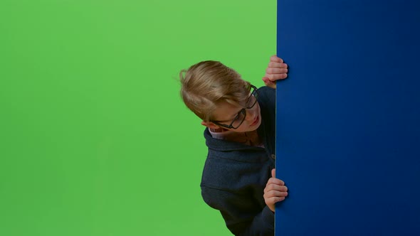 Child Boy Hands Are Taken in the Board Then There Is a Boy and Is Showing Dislike on a Green Screen