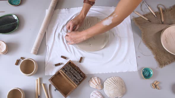 Female Sculptor Working in the Studio To Create the Original Plates