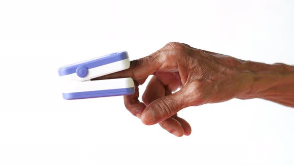 Senior Young Women Hand Using Pulse Oximeter Against White Background