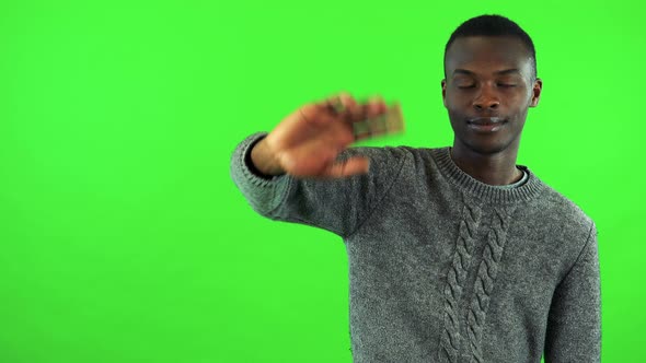 A Young Black Man Smiles and Waves at the Camera - Green Screen Studio