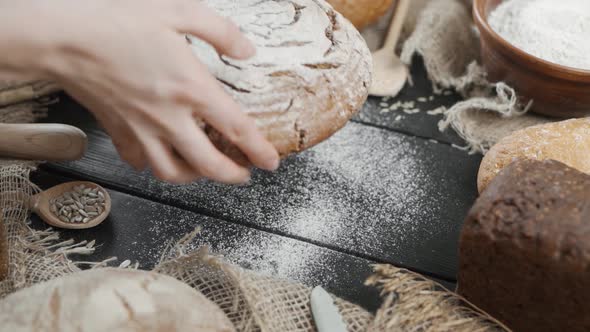 Bread Background - Various Types of Bread Are Served on the Table, a Woman Puts a Ready-made Loaf of