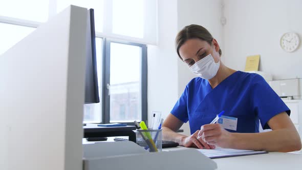 Doctor or Nurse in Mask with Clipboard at Hospital