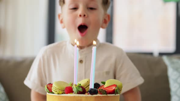 Happy Little Boy Blowing Candles on Birthday Cake