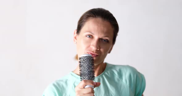 Beautiful Young Woman Sings and Holds Hairbrush As Microphone