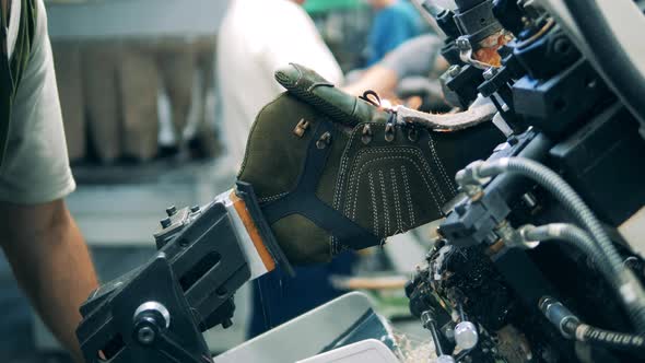 Factory Worker Shaping Shoe with a Machine. Lens Flare