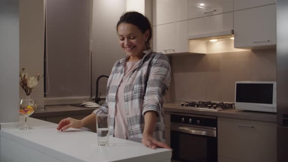 Adult Woman Drinking Glass of Water Enjoying Freshness Smiling Indoors