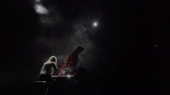 The Pianist Plays the Piano in the Backlight