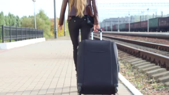 Girl With A Suitcase Leaves The Railway Platform