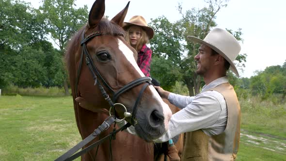 A Young Cowboy and His Sweet Daughter on Horseback