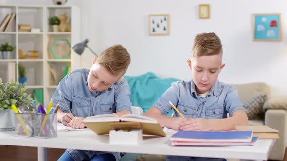 Identical Twins Studying Together at Home alt