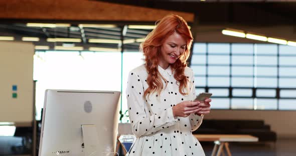 Businesswoman text messaging on mobile phone