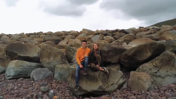 Couple Sitting on the Rocks at the West Coast of Ireland