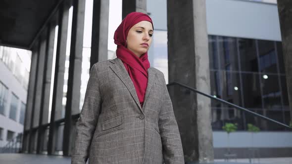 Young Beautiful Muslim Serious Woman Wearing Hijab Headscarf Walking Down Stairs Near Futuristic