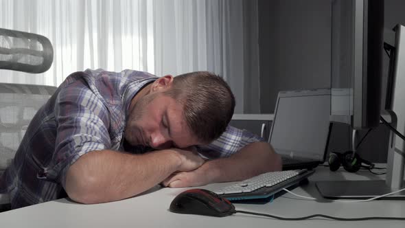 Man Sleeping on His Desk After Finishing Working on the Computer