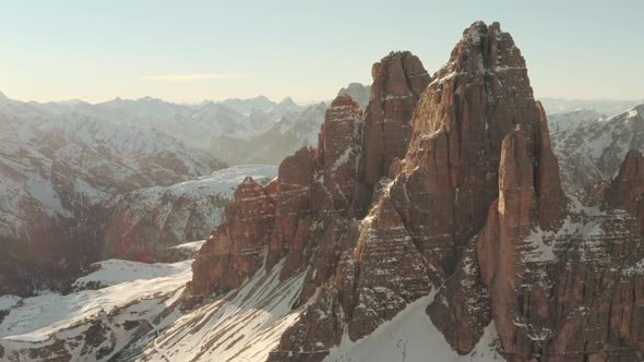 Circling drone shot of rear side of Tre Cime at sunset