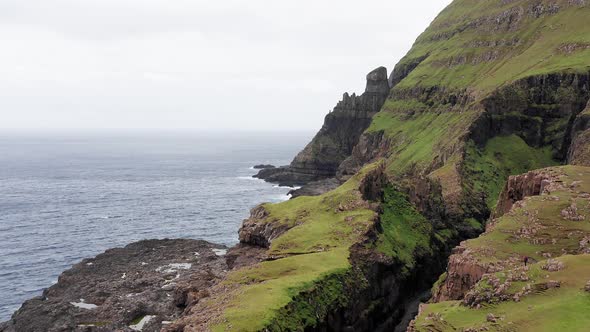 Aerial Back View of Huge Cliffs in Faroe Islands Green Rocky Mountainpowerful Ocean Wavesin a Cloudy