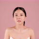 Slow motion Beauty shot of Beautiful Asian girl looking at camera isolated on pink background - VideoHive Item for Sale