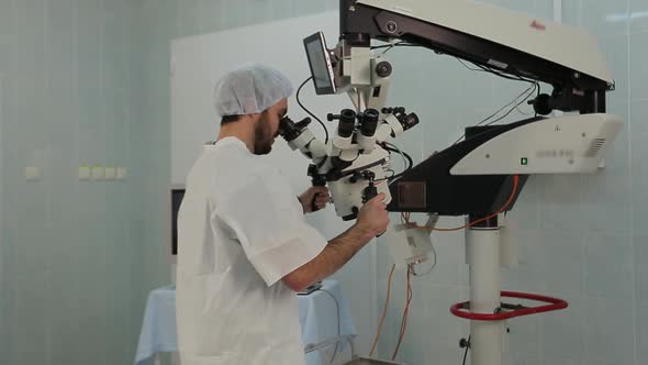 Man Using a Big Microscope System in a Medical Laboratory