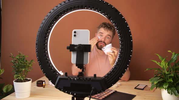 Young Man Filming His Video Blog Episode About New Cosmetic Products While