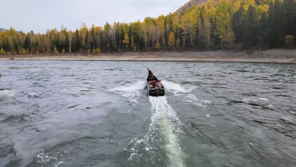 A Motor Boat Breaks the Waves of a Stormy River